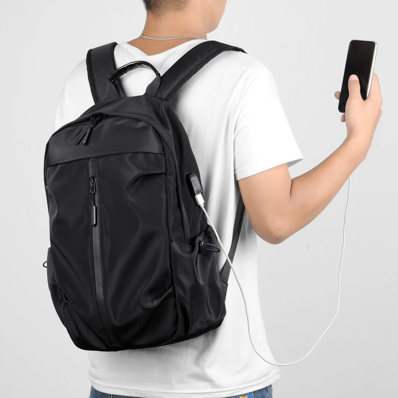 Simple solid color backpack with laptop compartment and USB charging port, suitable for travel, commuting, school, business