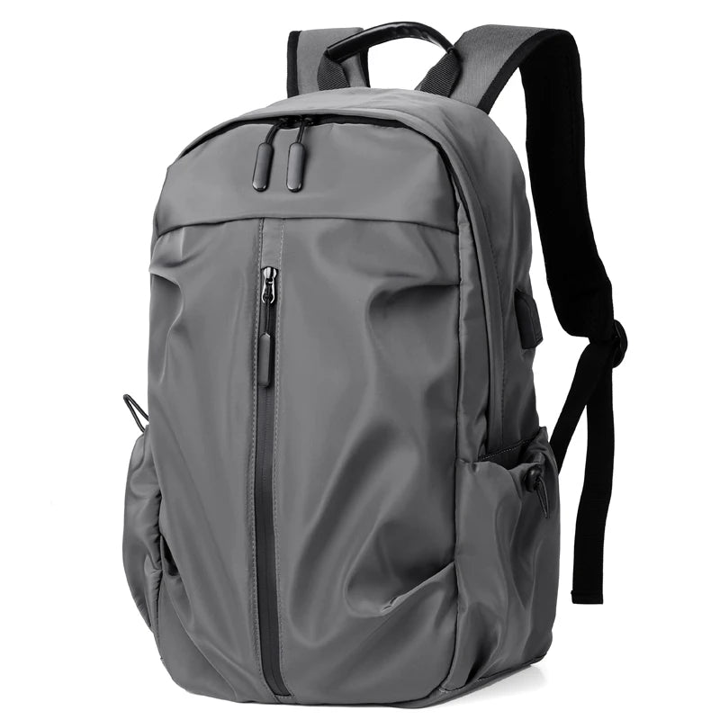 Simple solid color backpack with laptop compartment and USB charging port, suitable for travel, commuting, school, business
