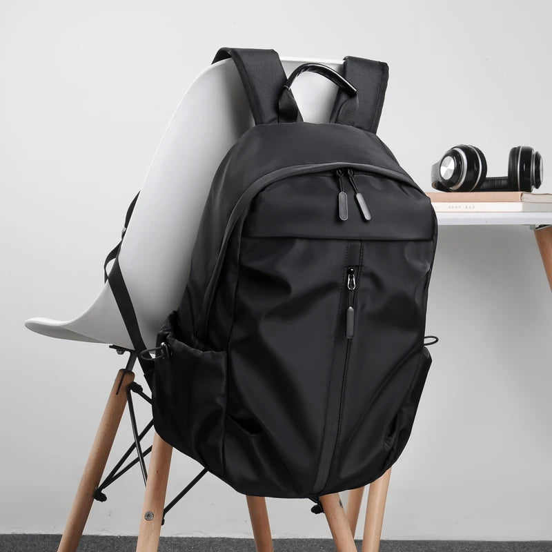 Simple solid color backpack with laptop compartment and USB charging port, suitable for travel, commuting, school, business